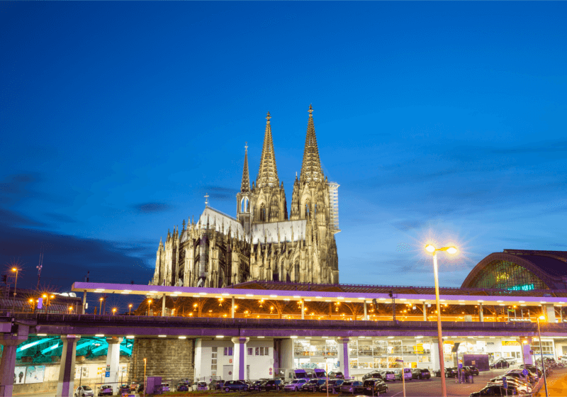 Eine Kirche wird abends angeleuchtet. Es ist der Kölner Dom. Das Wahrzeichen Kölns. 