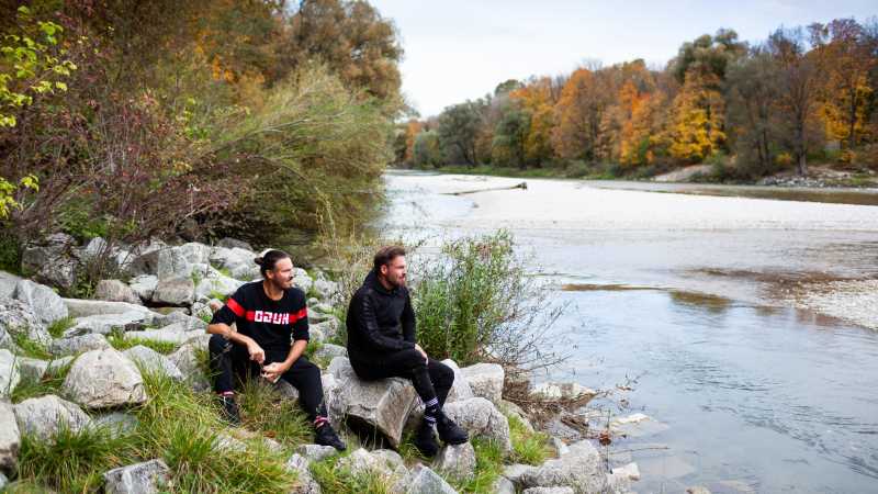 Christian und Knut Eckert sitzen an der Isar.