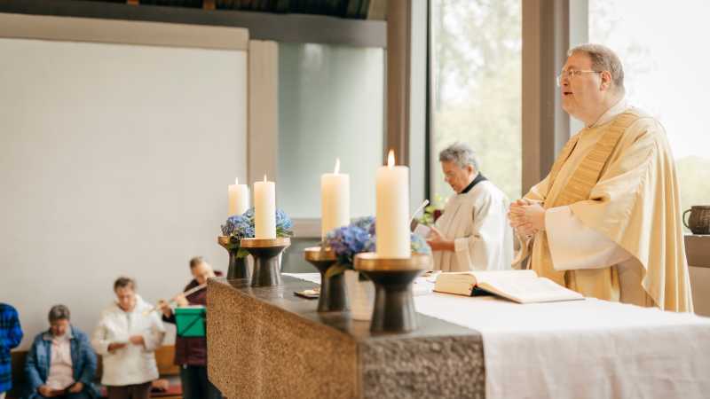 Pater Wolfram Hoyer steht am Altar und hält einen Gottesdienst ab.