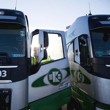 Vater und Sohn haben ihre LKW nebeneinander geparkt.