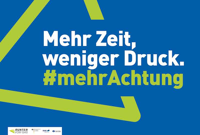 Blaues Autobahnplakat aus dem Jahr 2023 mit dem Slogan „Mehr Zeit, weniger Druck. #mehrAchtung“ in weißer und grüner Schrift. Grüne, winkelförmige Elemente, die ein Dreieck andeuten, erinnern an ein Verkehrsschild. Unten sind die Logos der Kampagne und ihrer Partner zu sehen.