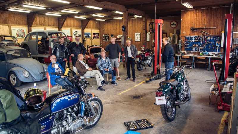 Gruppenfoto mit Oldtimer-Fans in einer Garage.