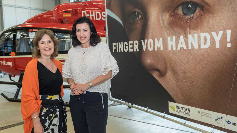 Dorothee Bär und Ute Hammer stehen vor einem der neuen Autobahnplakate 2017 mit der Aufschrift 