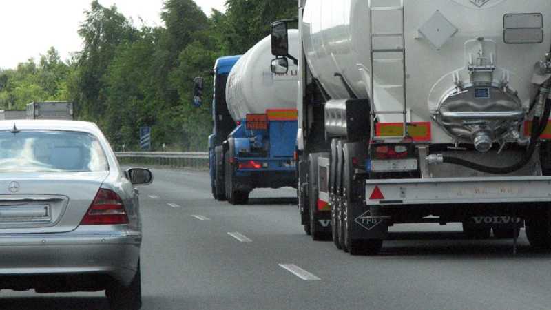 Das Bild zeigt eine Nahaufnahme einer Autobahn mit zwei LKWs.