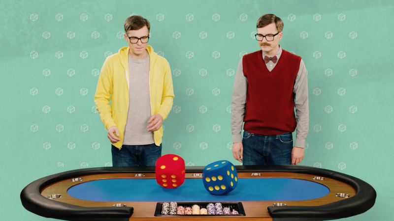 Das Bild zeigt zwei unterschiedlich gekleidete Ralph Caspers vor einem Casino-Tisch, auf dem ein blauer und ein roter Würfel liegen.