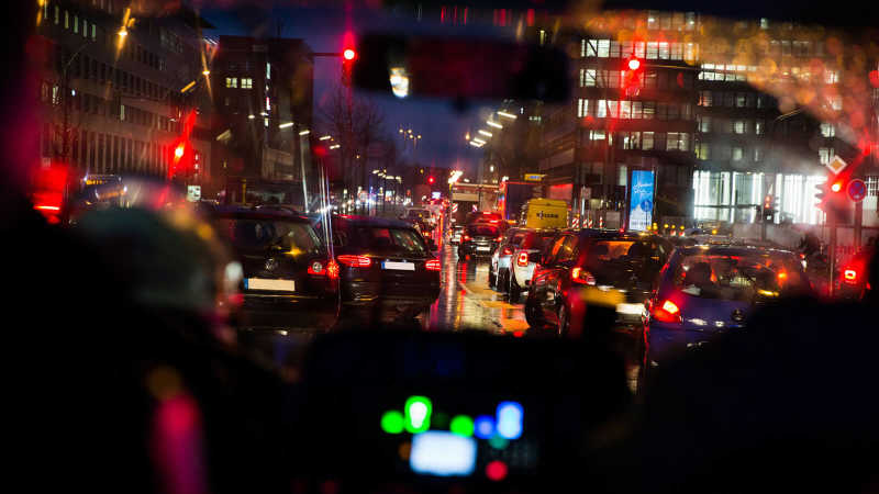 Das Bild zeigt die Perspektive aus einem fahrenden Feuerwehrfahrzeug heraus während eines Einsatzes. Die im Weg stehenden Autos bilden eine Rettungsgasse.