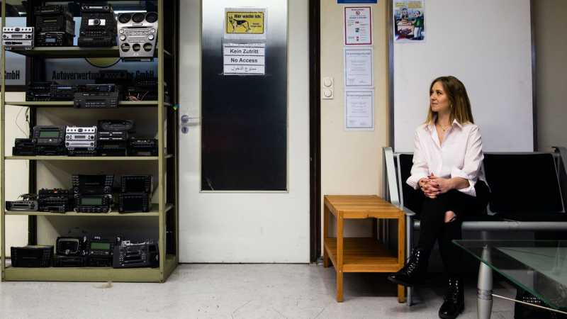 Das Bild zeigt eine junge Frau in den Büroräumen eines Schrottplatzes. 