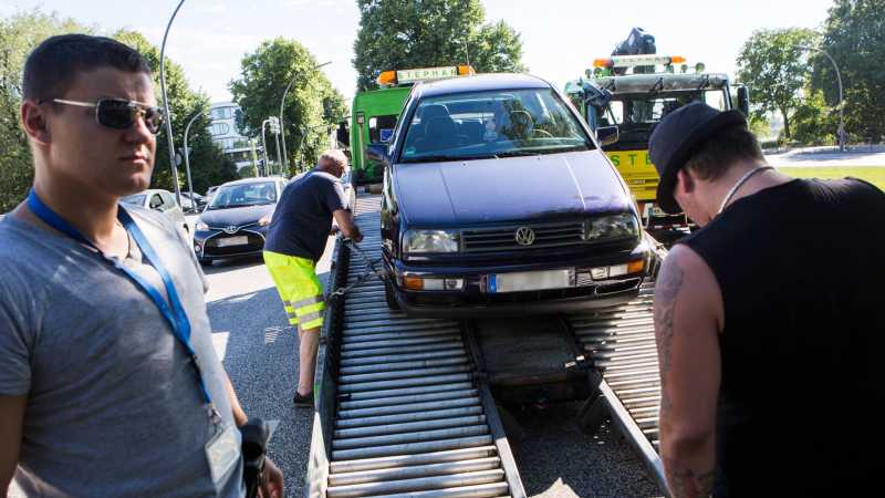 Das Bild zeigt einen Abschleppdienst-Dienst, der gerade ein Fahrzeug auflädt.