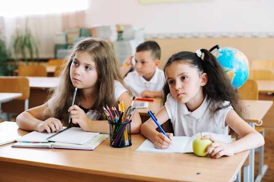 niños en la escuela sentados prestando atención