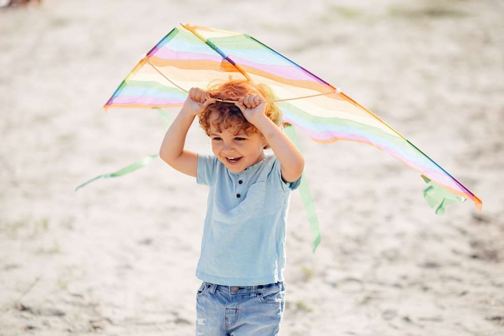 niño pequeño feliz, volando cometa