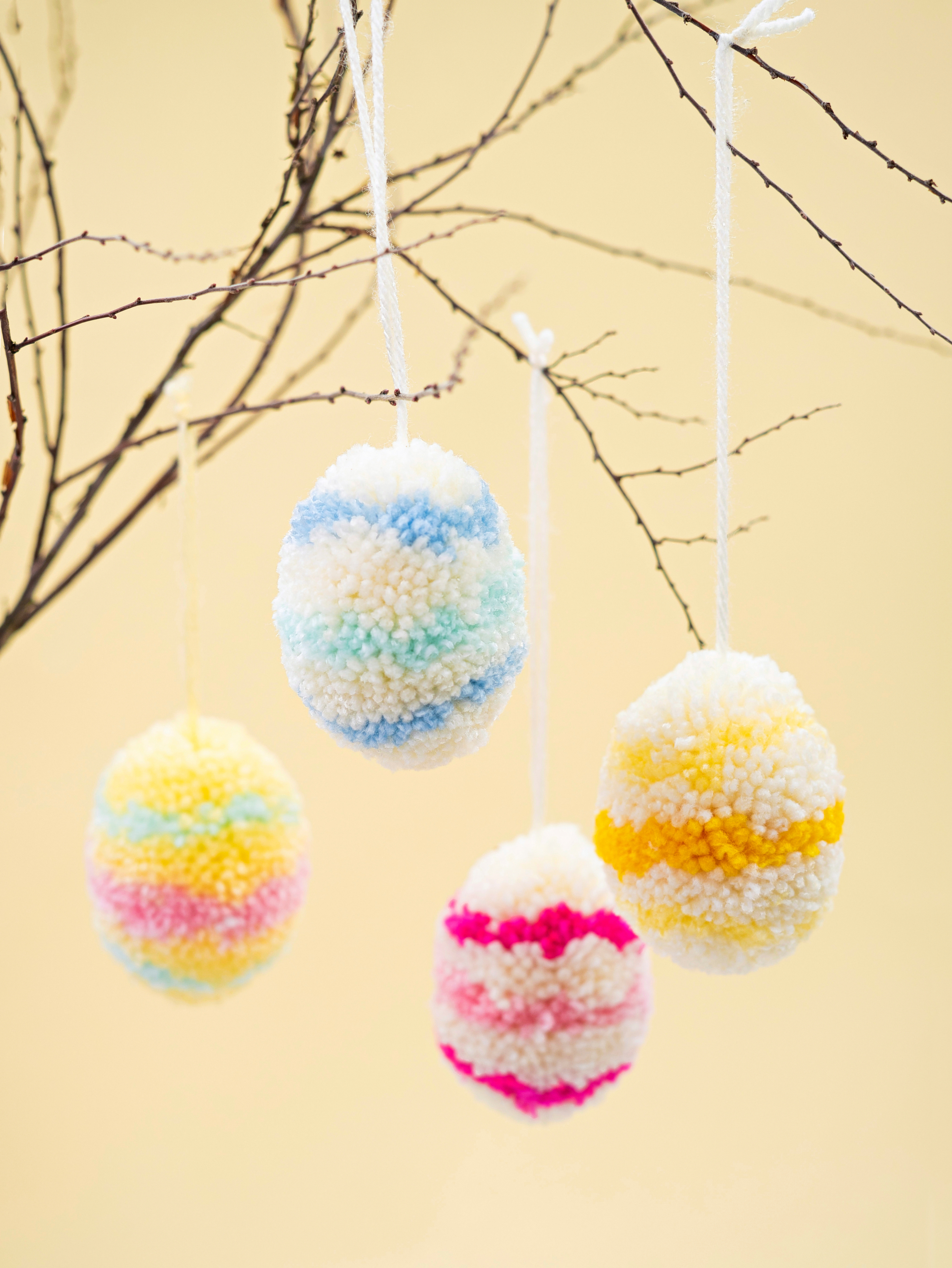 completed pompom Easter eggs hanging