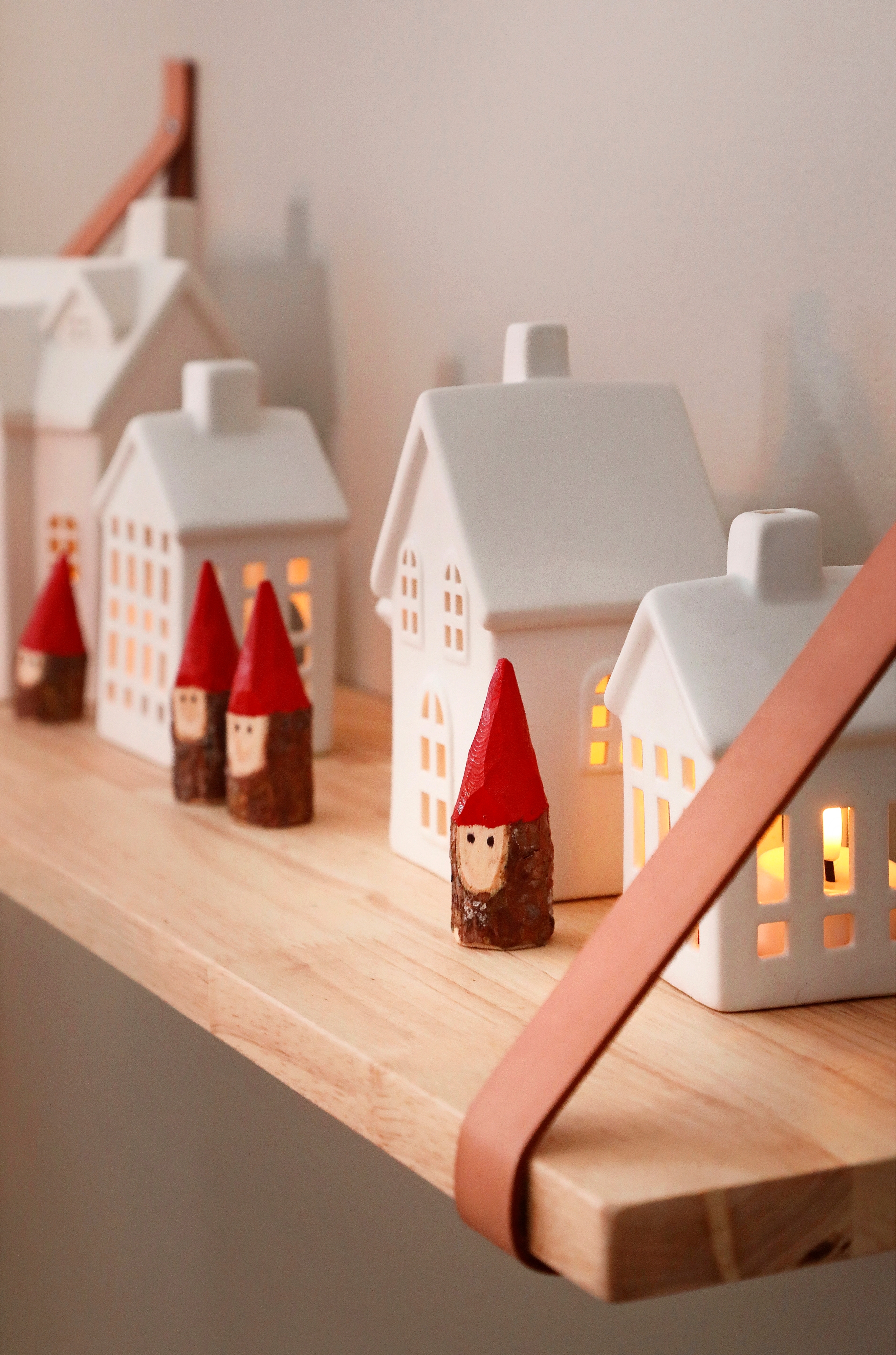 Elves and little house lanterns on a shelf