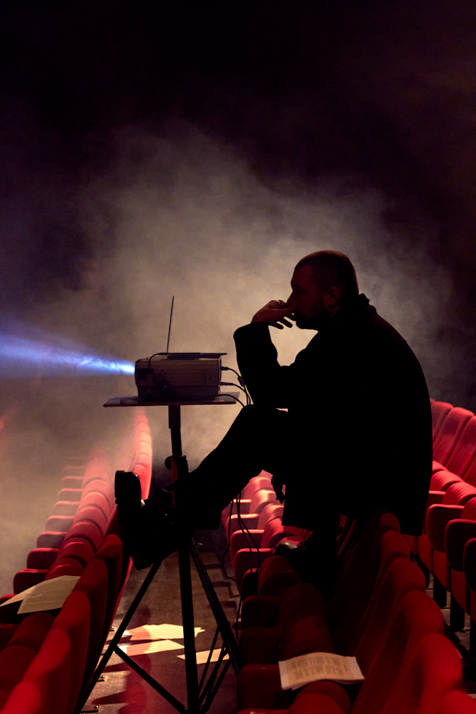 Alexander Wessely silhouette from the side while projecting art to the stage