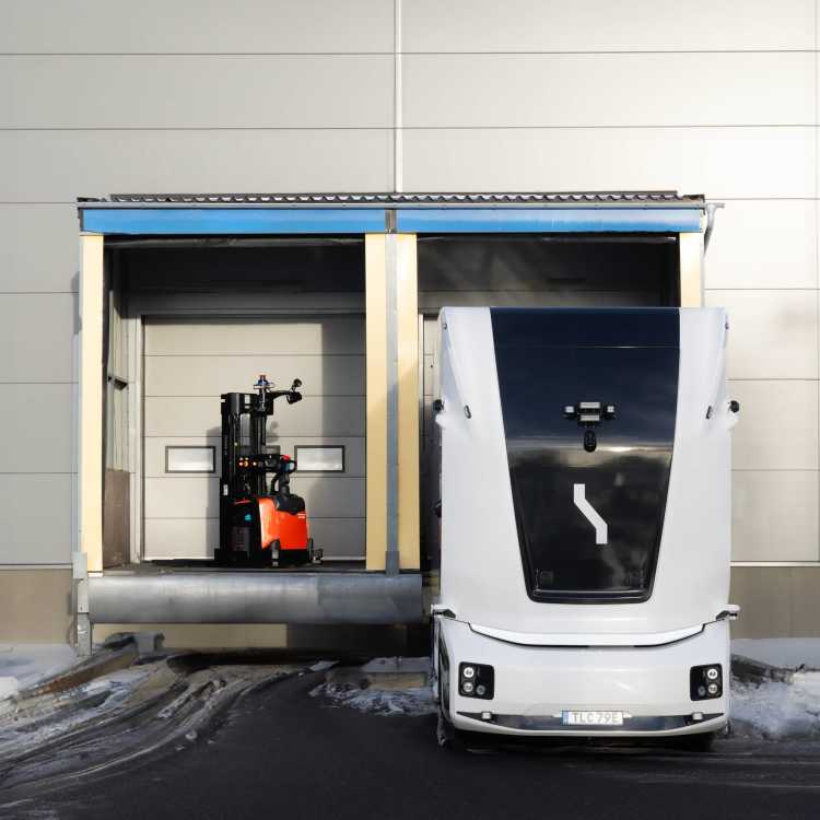 An electric autonomous vehicle and an electric autonomous forklift by a loading dock
