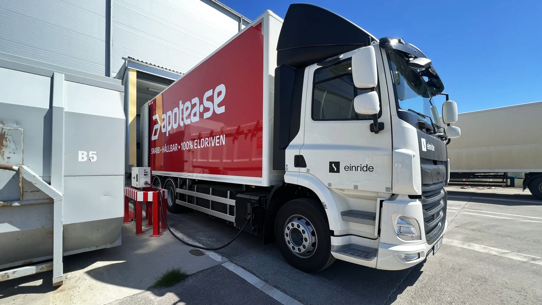 Connected electric truck with Apotea foiling driving out of garage 