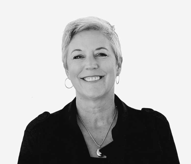 A woman with a black shirt and silver necklace with short light hair smiling.