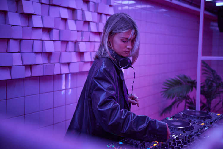 Hadla Bergman djing by DJ set in room with pink light