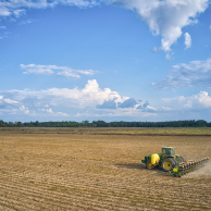 Open landscape view of a tractor with SIMPAS equipment planting in the distance