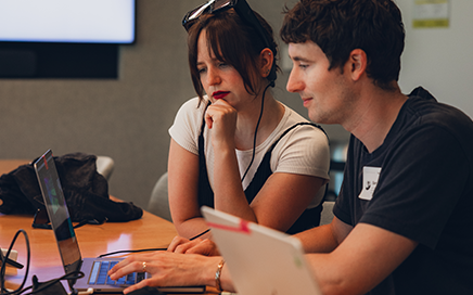 Image showing two people collaborating on laptops, symbolizing the global creator community