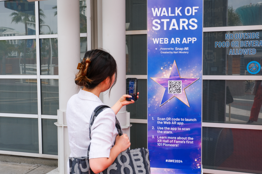 A woman uses AWE's Hall of Fame WebAR Experience while at the Augmented World Expo.