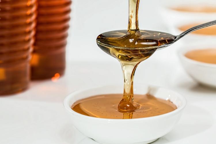 Measuring spoon of liquid honey