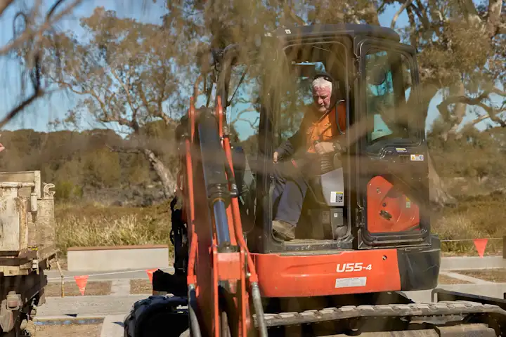 Construction worker operating excavator at memorial park