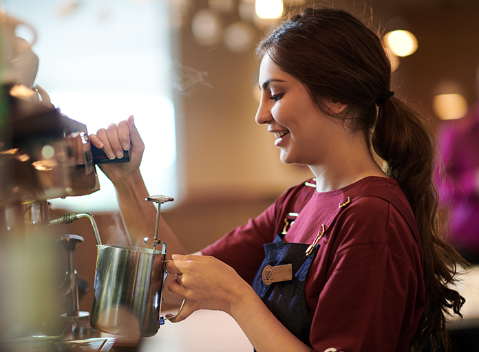 A Costa Coffee Barista steaming milk