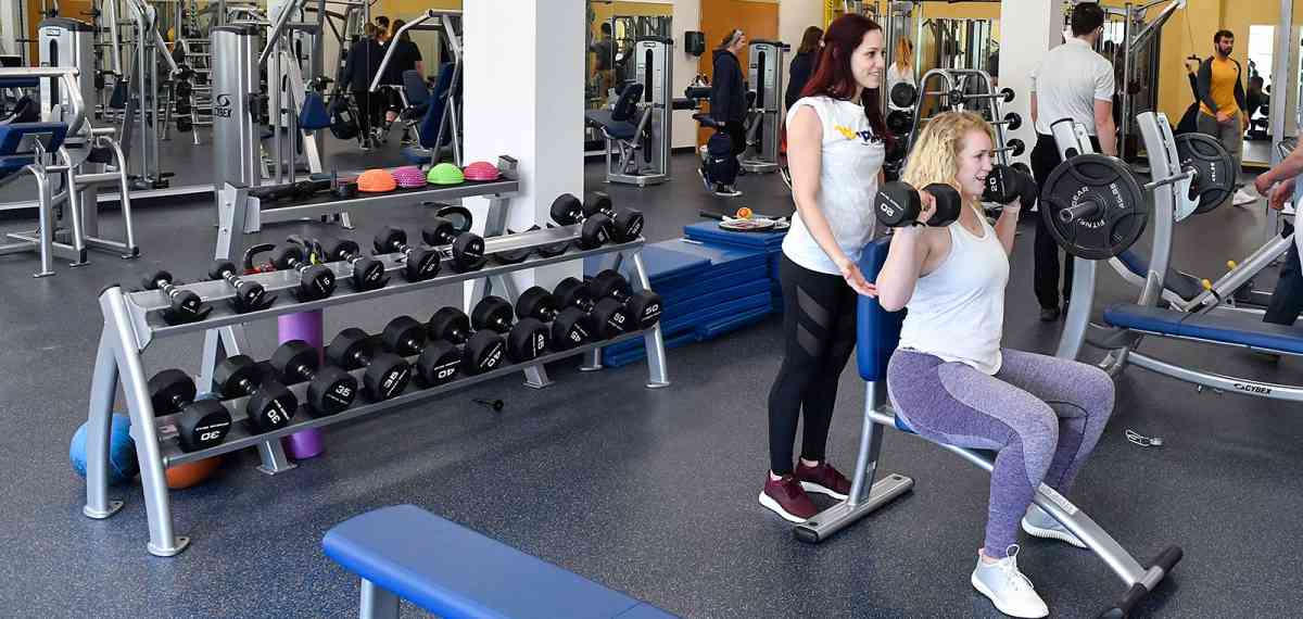 Two women lifting weights in a gym