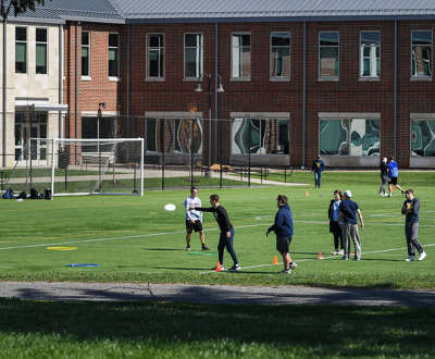 Students playing a game with Frisbees and rings on the Rec Fields