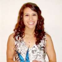 Smiling woman with long hair holding a trophy.