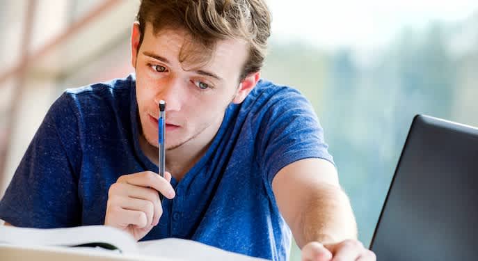 Picture of a student studying in front of a laptop. 