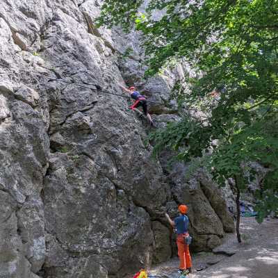 Emi is climbing up on the route while Christoph is belaying her.