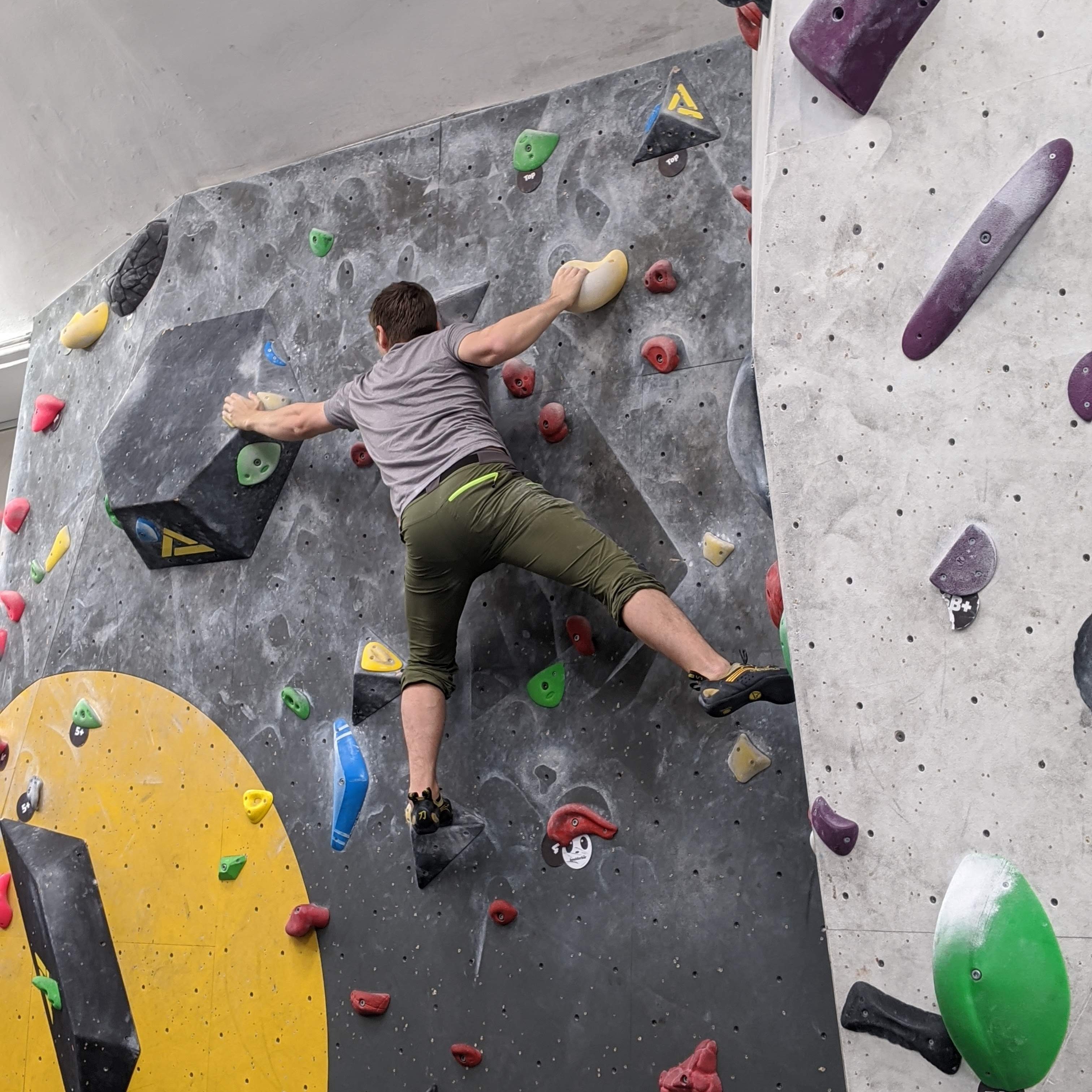 Me climbing on a yellow boulder problem