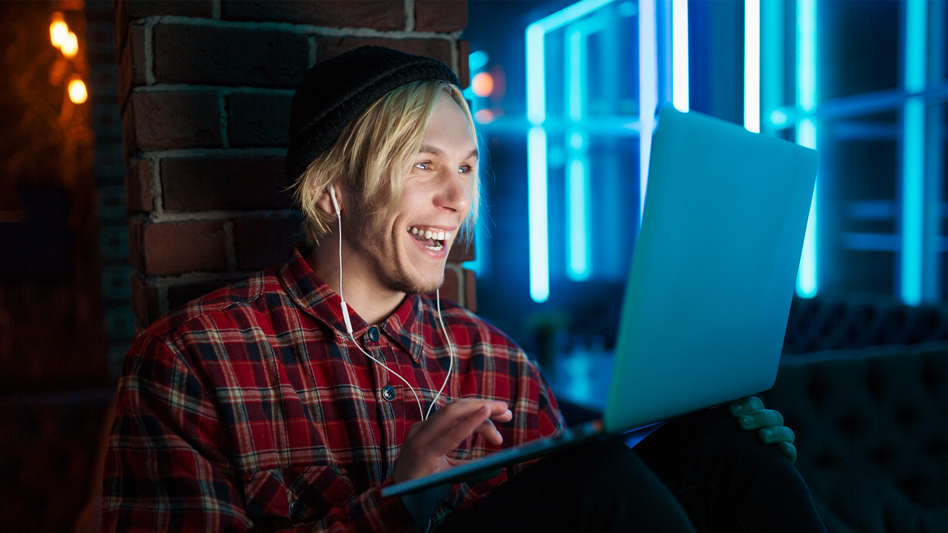 A person sitting at home with headphones on, having an online meeting thanks to cloudification.