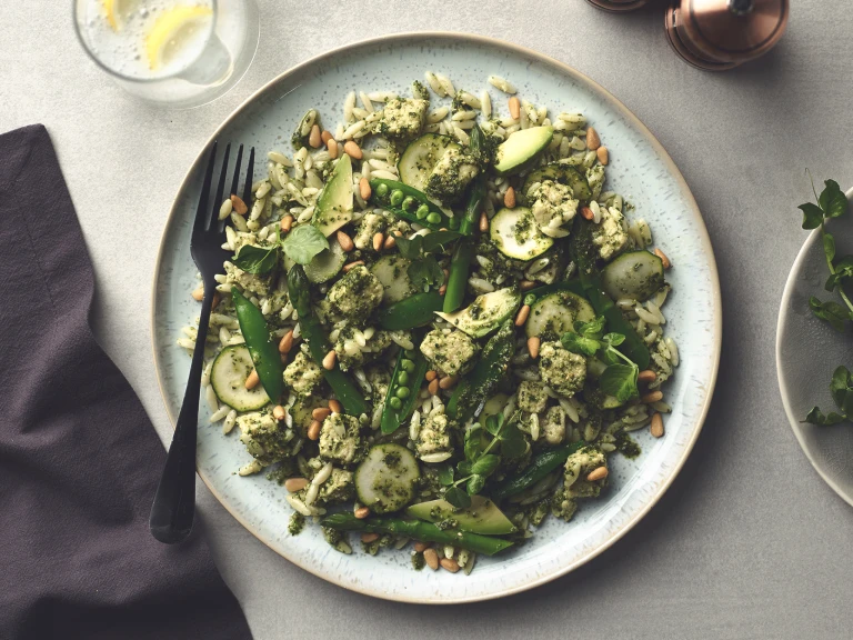 Orzo Pasta with asparagus, zucchini, sugar snap peas, avocado, Quorn Pieces, and pesto topped with pine nuts.