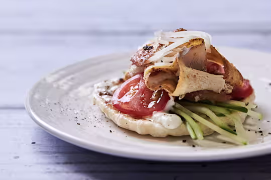 A vegetarian shawarma made with Quorn Roast, tomatoes, cucumber, onions, and a vegan yoghurt sauce atop a homemade flatbread.