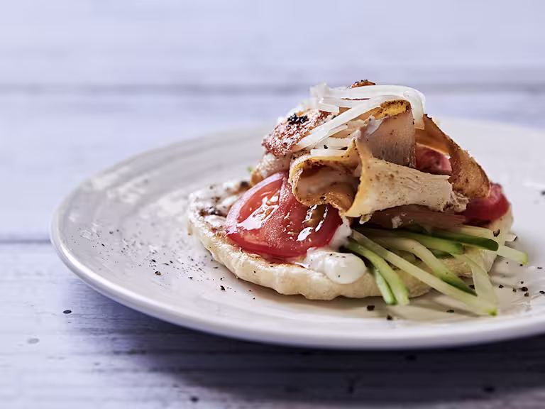 A vegetarian shawarma made with Quorn Roast, tomatoes, cucumber, onions, and a vegan yoghurt sauce atop a homemade flatbread.