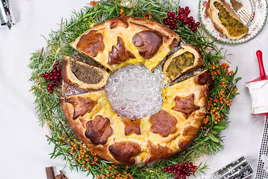 Vegan sausage and butternut squash colcannon wreath, with a piece cut opening facing upwards and a piece on the side.