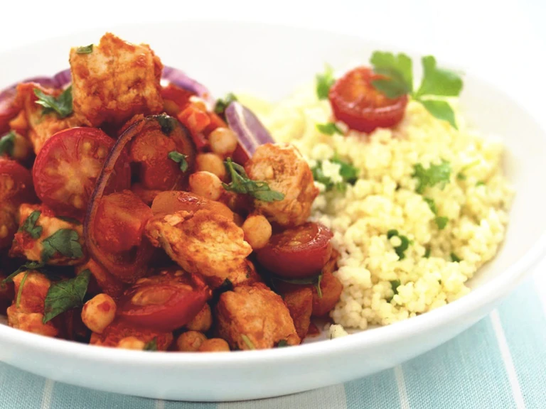 Moroccan tagine recipe made with Quorn Pieces, chickpeas and tomatoes served with couscous in a white dish