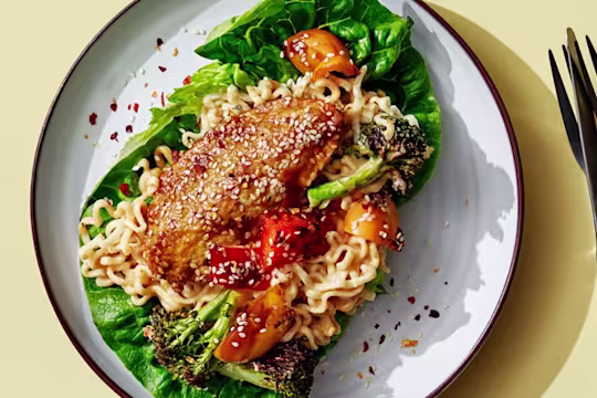 Vegetarisk teriyakigratäng med Quornfiléer serverad på en salladsbädd serverad med en kopp och kniv och gaffel