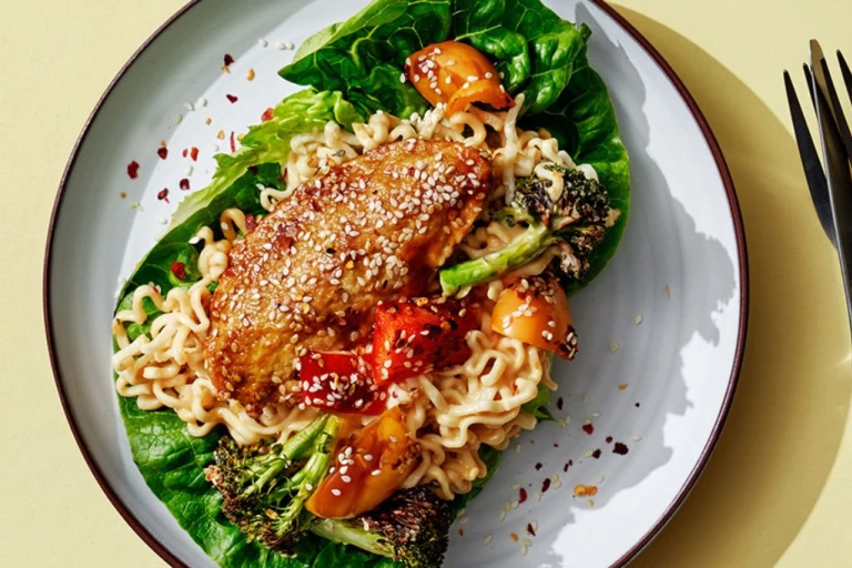 Vegetarisk teriyakigratäng med Quornfiléer serverad på en salladsbädd serverad med en kopp och kniv och gaffel