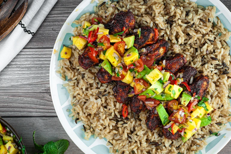 Jerk spiced Quorn Meatless ChiQin Fillets with avocado and mango salsa served in a blue bowl.