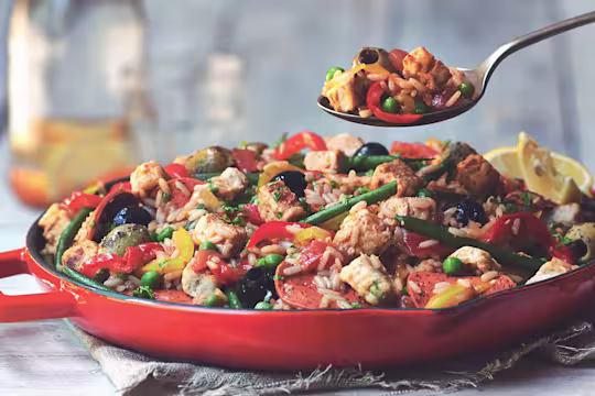 Vegetarian paella recipe made with Quorn Vegan Pieces, Quorn Vegan Pepperoni Slices and vegetables served in a red pan