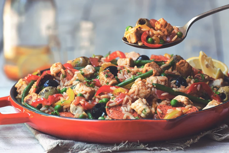 Vegetarian paella recipe made with Quorn Vegan Pieces, Quorn Vegan Pepperoni Slices and vegetables served in a red pan