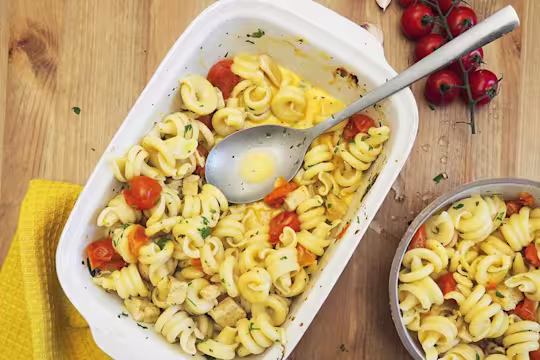 Baking dish of pasta with cherry tomatoes and baked quorn pieces; sprinkled with herbs