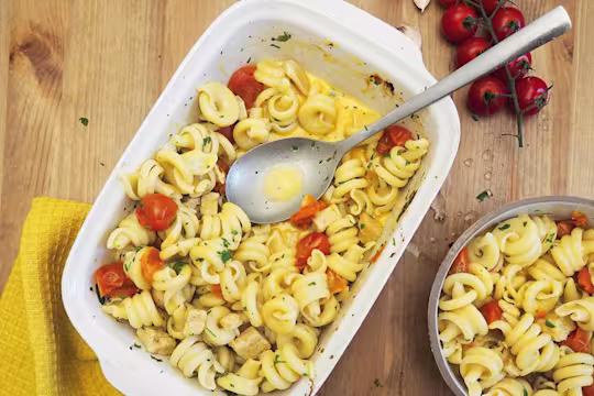 Baking dish of pasta with cherry tomatoes and baked quorn pieces; sprinkled with herbs