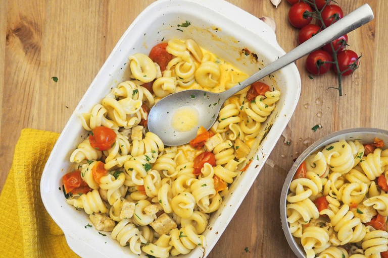 Baking dish of pasta with cherry tomatoes and baked quorn pieces; sprinkled with herbs
