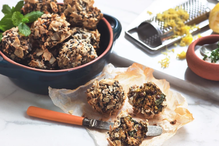 Vegetarian party food of Quorn Mince and Lentil Meatball bites served in a bowl with a couple on the side and one cut in half