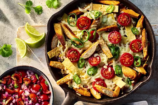 Vegetarian Migas with Quorn Fillets visible on the top of the dish served with a side of salsa.