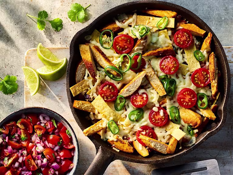 Vegetarian Migas with Quorn Fillets visible on the top of the dish served with a side of salsa.